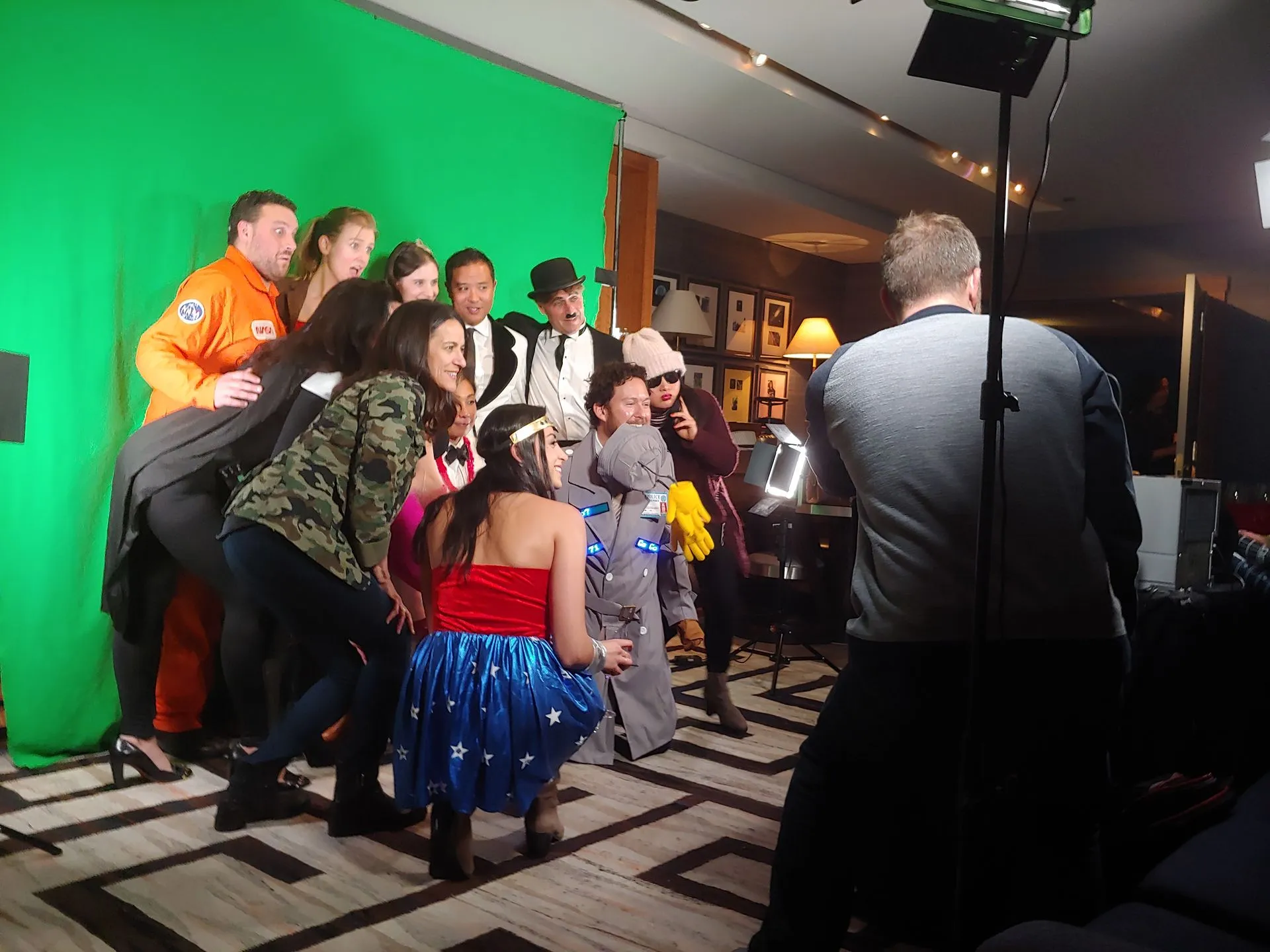 Costumed guests crowding the green screen while the crew shoots